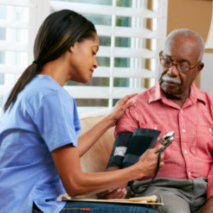 caregiver helping senior woman drink her water