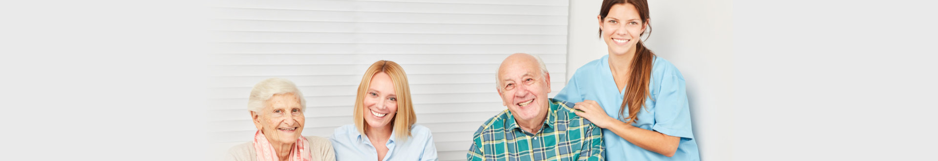 Happy family with senior couple and nurse in a retirement home