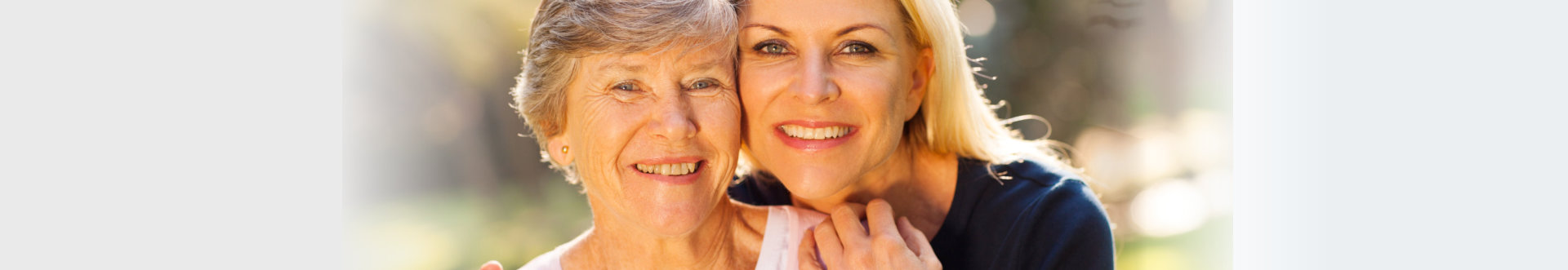 Smiling senior women and middle aged daughter outdoors closeup